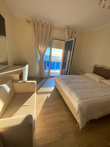 都拉斯Hotel 3 Vellezerit的一间卧室设有一张大床和一个大窗户