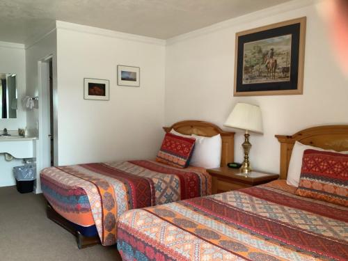 独立城Independence Courthouse Motel的酒店客房,设有两张床和一盏灯