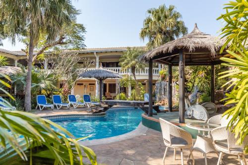 亚松森Paramanta Lifestyle Hotel的一个带游泳池和椅子的度假胜地和一座建筑