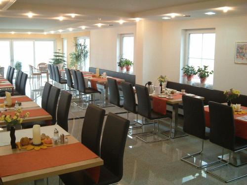威森斯海德Hotel Retterath am Nürburgring的用餐室设有桌椅和窗户。
