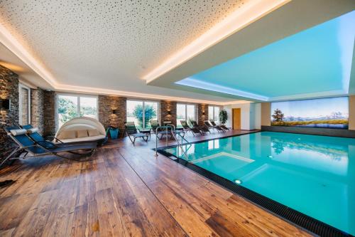 拉德施塔特塔克萨霍夫酒店的一座带大窗户的房屋内的游泳池
