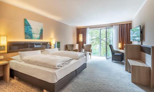 希尔德斯海姆伯格豪彻公园酒店的酒店客房设有一张大床和一张书桌。