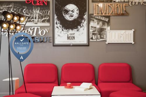 蒙特勒伊巴黎玛丽德蒙特勒伊宜必思尚品酒店的一间设有两张红色椅子和海报的等候室