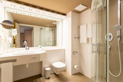 希尔德斯海姆伯格豪彻公园酒店的浴室配有卫生间、盥洗盆和淋浴。