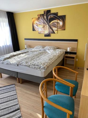 考波什堡Rómahegy Rendezvényház的一间卧室配有一张床和两把椅子
