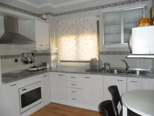 普拉多德尔雷Casa Las Lomas的厨房配有白色橱柜和桌子