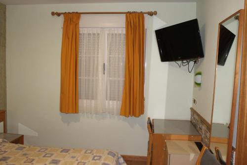 维拉弗兰卡·德尔·比尔Hostal Burbia的一间卧室配有一张床和一台平面电视
