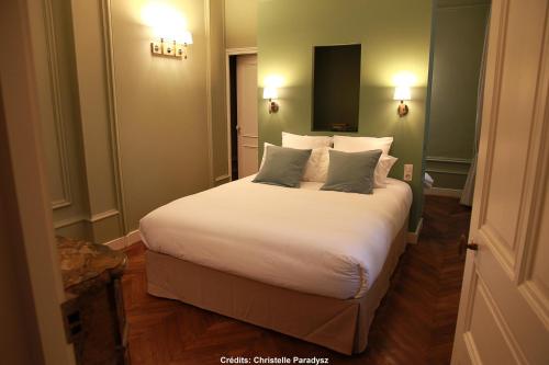 拉弗雷切Hôtel Le Gentleman的卧室配有一张带白色床单和枕头的大床。
