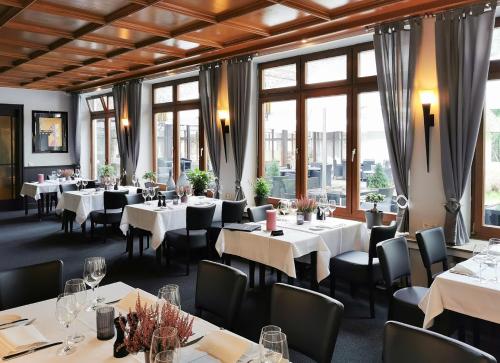 索尔陶索尔陶尔海德花园酒店的餐厅设有白色的桌椅和窗户。