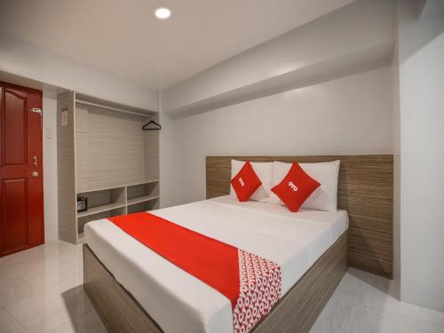 马尼拉OYO 675 Circuit Hostel的一间卧室配有一张带红色枕头的大床