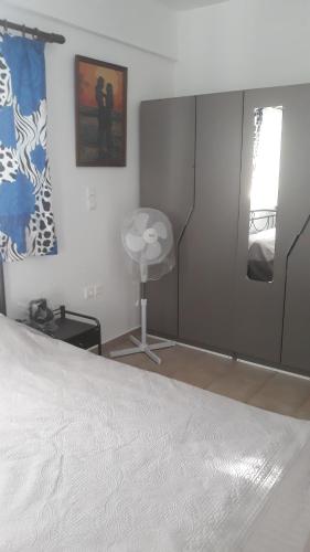 阿特米达Nina Rooms (apartments)的一间卧室设有一张床、一个窗口和风扇