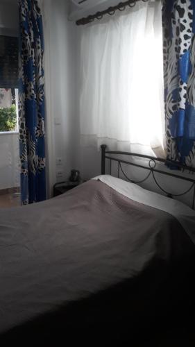 阿特米达Nina Rooms (apartments)的一间卧室配有床和带窗帘的窗户