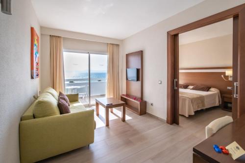 阿尔库迪亚港Hotel Condesa的酒店客房设有沙发、床和窗户。