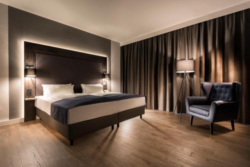 柏林柏林城西假日酒店的一间卧室配有一张床和一把椅子