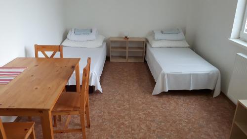 利托梅日采Ubytovna Koupaliště的客房设有两张床、一张桌子和一张桌子。