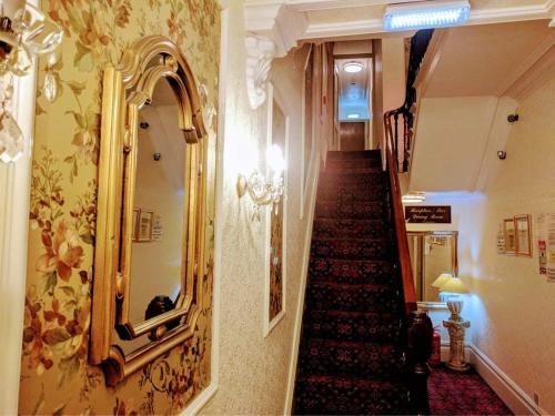 布莱克浦Gleneagles - Albert Road的走廊上设有楼梯,墙上有镜子