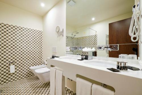 辛特拉辛特拉精品酒店的浴室设有2个水槽、卫生间和镜子。