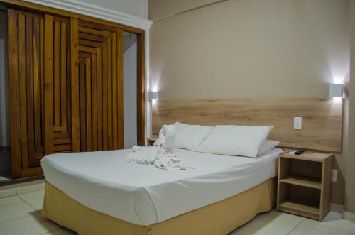 马塞约Aram Ouro Branco Hotel的一间卧室配有一张大床和木制床头板
