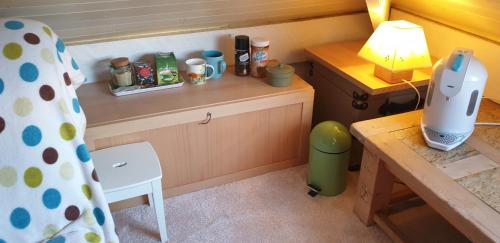 切斯特Le studio fridge tv microwave,的小厨房配有书桌和带台灯的桌子