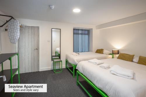 布莱克浦ApartHotel421 by Seafront Collection的带两张床和镜子的客房