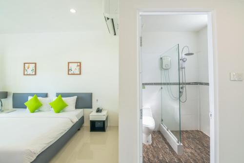 攀牙Katathong Golf Resort & Spa的一间卧室设有一张床、淋浴和卫生间