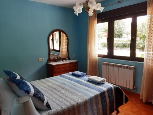 贝尔蒙特·德米兰达Casa Entremolin的一间蓝色卧室,配有一张床和镜子