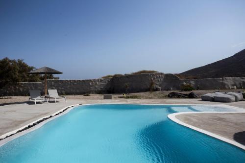 FoinikiáVilla Beltramo Santorini 2 bedroom private pool villa的一个带两把椅子和遮阳伞的大型蓝色游泳池