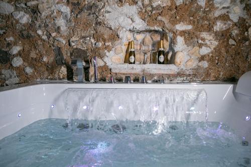 萨莱诺Salerno Mare e Luci Deluxe的装满水的浴缸,装有两瓶葡萄酒