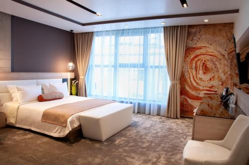 舒门Family Hotel Business Club的一间卧室设有一张大床和一个大窗户
