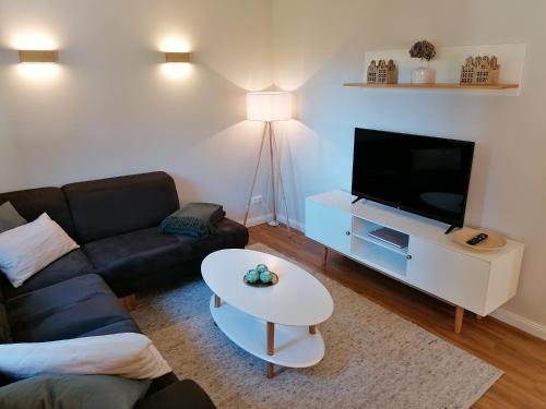 OldendorfStrohböhn的带沙发、电视和桌子的客厅