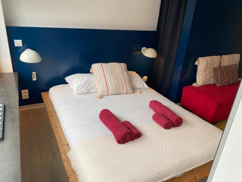列日Studio Peralta的宿舍间内的两张床,上面有红色毛巾