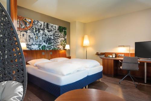 波茨坦波茨达姆塞米钠里斯海洋酒店的配有一张床和一张书桌的酒店客房