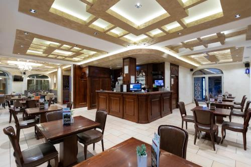 苏博蒂察Garni Hotel Royal Crown的一间带桌椅的餐厅和一间酒吧