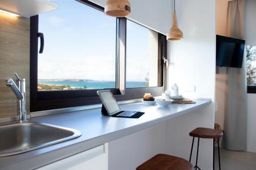 埃斯卡洛Gaviota - Emar Hotels Adults Only的厨房配有带窗户的台面上的笔记本电脑