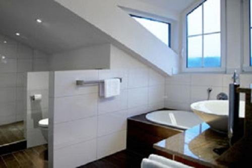 黑林山区克尼格斯费尔德拉普咖啡餐厅旅馆的浴室配有盥洗盆和浴缸。