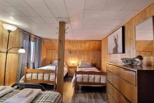 圣弗朗索瓦小河Le Chic-Rustique - SPA, chaleur, rustique的一间设有三张床的房间和一张桌子