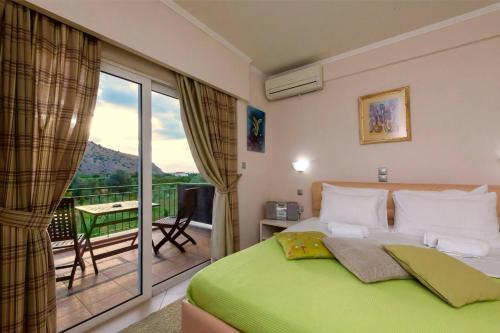 纳夫普利翁阿纳斯塔西娅旅馆的一间带绿色床的卧室和一个阳台