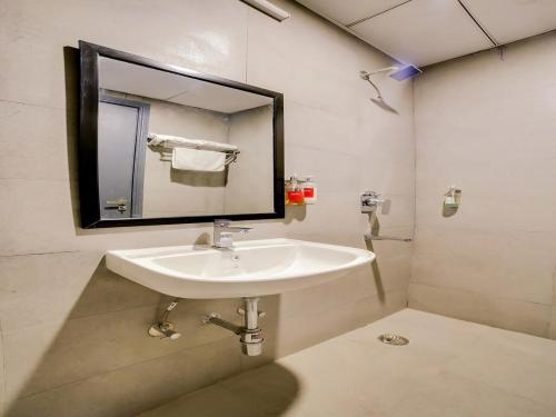 古尔冈Flora Residency的浴室设有白色水槽和镜子