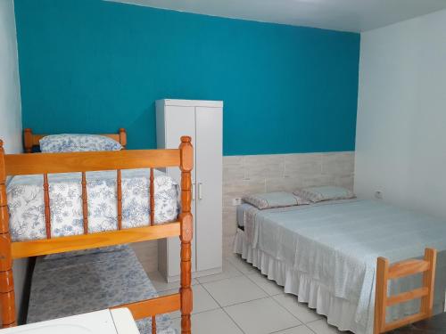 卡纳内亚Pousada Ancoradouro的一间卧室设有两张双层床和蓝色的墙壁