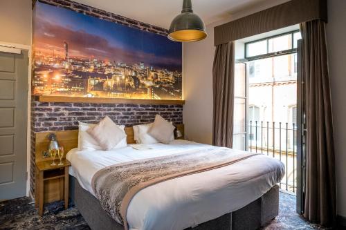 曼彻斯特阿贝尔海伍德精品酒店的一间卧室设有一张带砖墙的大床