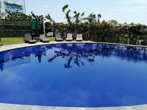 查帕拉Memora Chapala的一座带躺椅的大型蓝色游泳池,位于庭院内