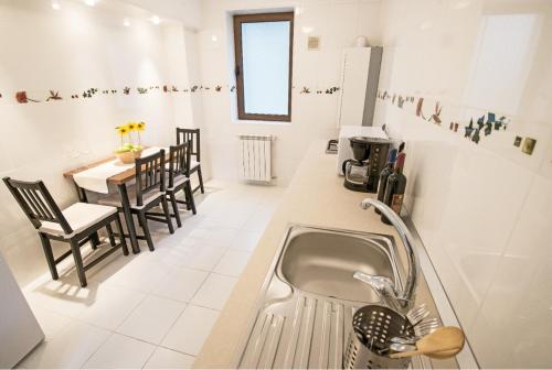 普雷代亚尔6 Apartments的厨房配有水槽和桌椅