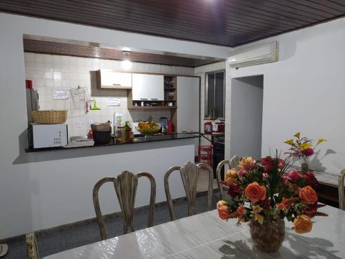 萨尔瓦多Hostel My Place Hospedaria的厨房配有一张桌子,上面放着花瓶