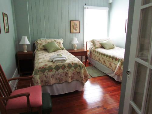 布鲁克斯维尔Ardendales的一间卧室设有两张床、一把椅子和一个窗户。