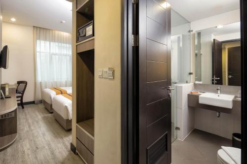 雅加达Oria Hotel Jakarta的一间带水槽、卫生间和镜子的浴室