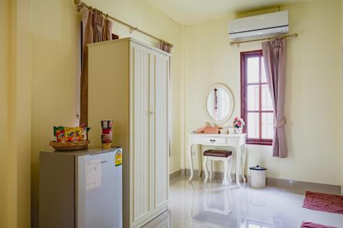 北碧Sakarin Valley Resort的厨房配有冰箱、桌子和窗户。