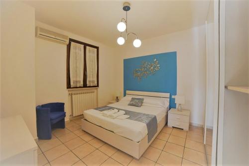 西尔米奥奈ALLORO APPARTAMENTO 1 - Piano Terra con terrazza.的一间卧室设有一张床和蓝色的墙壁
