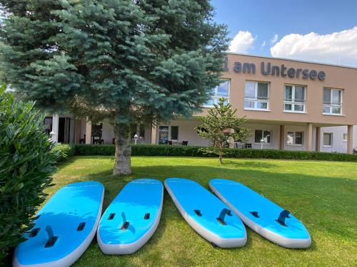 Bantikow埃姆昂特斯酒店的坐在建筑物前面的草上四块蓝色冲浪板