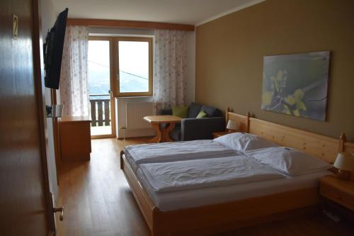 绍萨尔地区基策克Gästehaus-Temmel-Kitzeck的一间卧室配有一张床、一张沙发和一个窗口