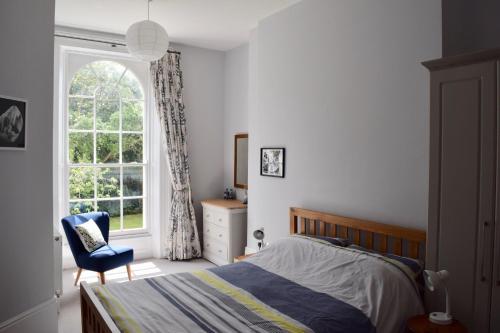 埃克塞特Luxury City Centre Apartment, Exeter.的一间卧室设有一张床、一个窗口和一把椅子